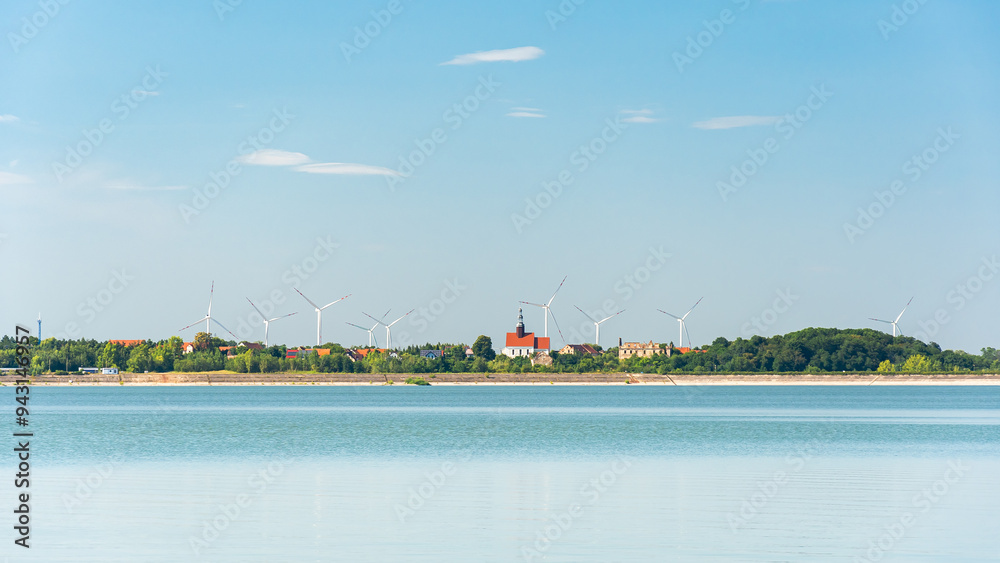 Mietkowski Reservoir, view of the town of Mietkow and the nearby wind farm. A popular place for summer recreation and water sports, view from the water on a summer day.