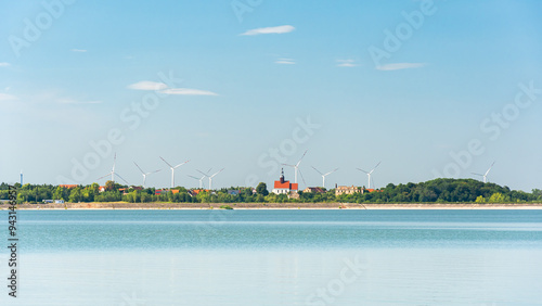 Obraz na płótnie Mietkowski Reservoir, view of the town of Mietkow and the nearby wind farm. A popular place for summer recreation and water sports, view from the water on a summer day. w salonie