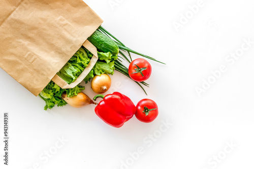 Healthy food with fresh vegetables in paper bag on white backgro photo