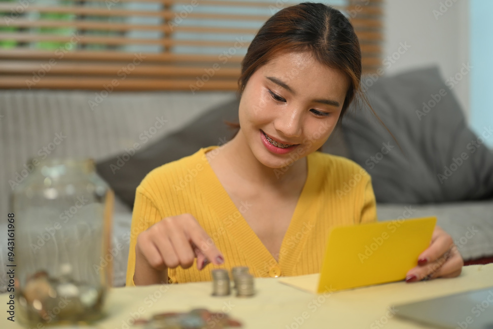 Pretty asian woman counting coins on table, managing home budget. Financial responsibility concept Pretty asian woman counting coins on table, managing home budget. Financial responsibility concept