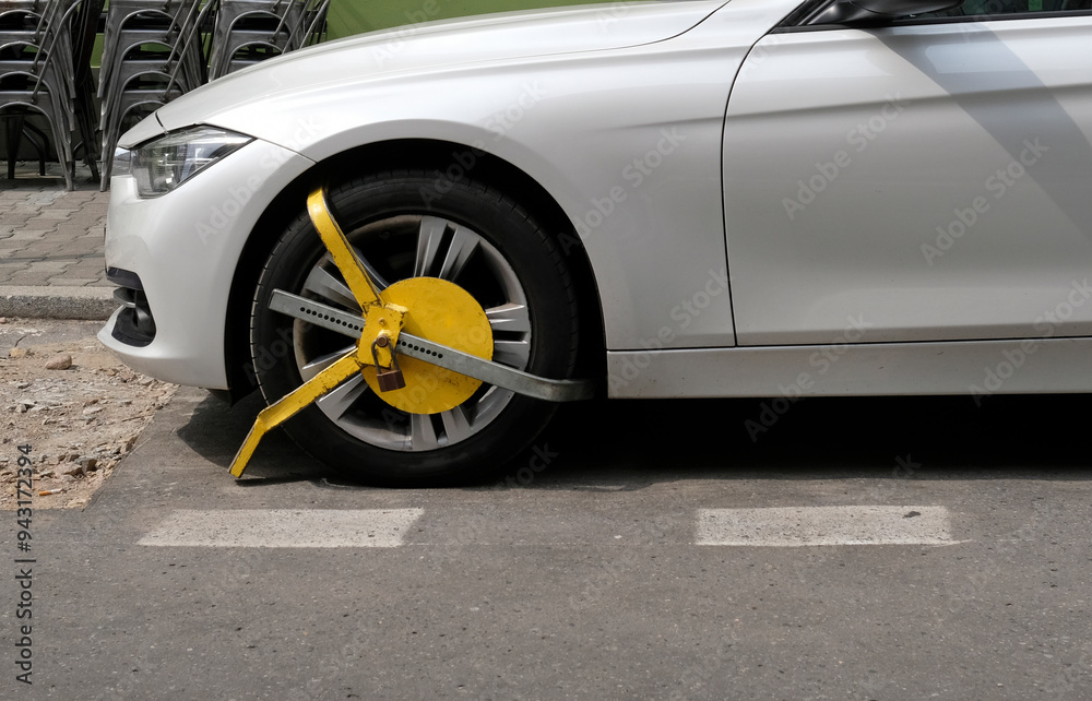 Obraz premium Wheel clamp or parking claw on a car front wheel