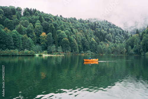 Artvin, Karagol. Foggy weather, magnificent view surrounded by lush green trees. People are rowing on the lake and enjoying the magical view.