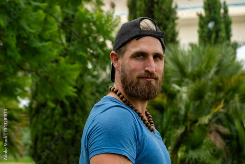 Outdoor Fitness Instructor with Cap and Red Beard Smiles at Camera in Park