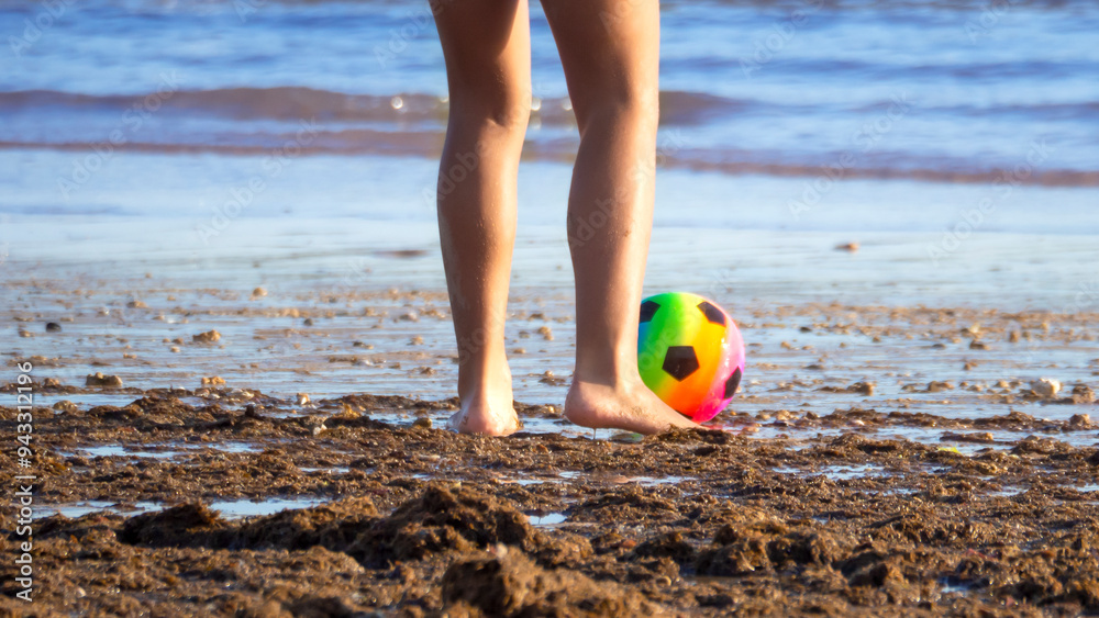 Obraz premium People playing soccer on the beach, just feet and a ball.