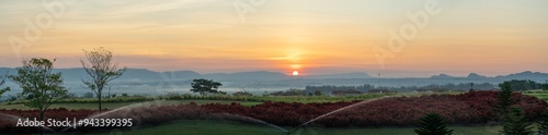Panorama beautiful garden with village background in fog while sunrise