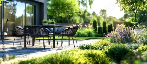 Modern patio furniture nestled in a lush green garden with vibrant purple flowers