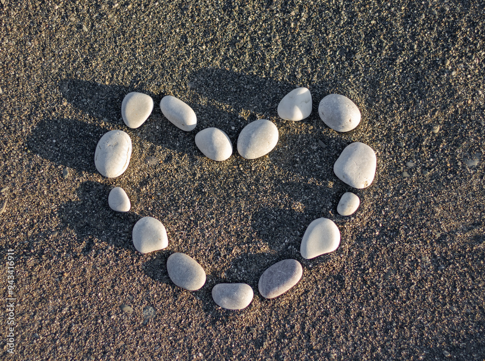 Heart shape made of stones on sea sand