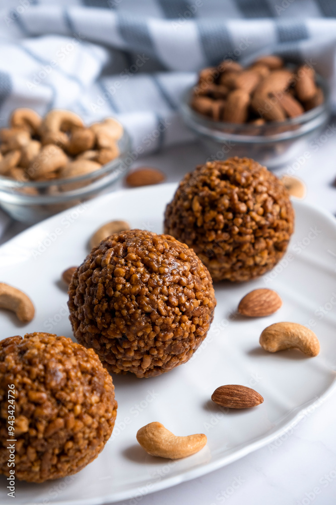 Healthy raw dessert, bliss balls of nuts cashew and almonds on white plate. Energy balls for healthy eating. Gluten off, sugar free candies made of nuts. Healthy raw dessert, bliss balls of nuts cashew and almonds on white plate. Energy balls for healthy eating. Gluten off, sugar free candies made of nuts.