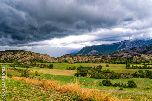 View to a mountain ridge in the French Maritime Alps with haze and heavy cloud cover.