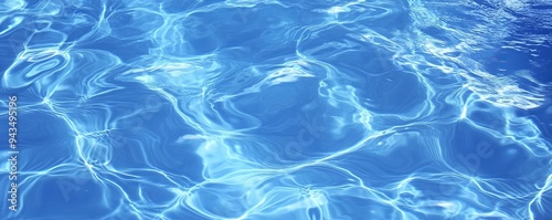 Abstract blue water ripples with sunlight reflections, creating a serene and tranquil mood.