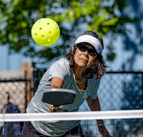 Pickleball player hits the ball right towards cameera photo