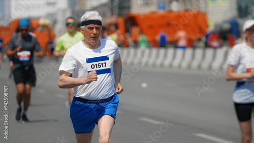 Male old runner jog sport marathon. Senior man athlete run. Elder jogger work out urban park. 60s sportsman train body. Health city life. Fast race slow motion. Active fit track. Motivation concept. photo