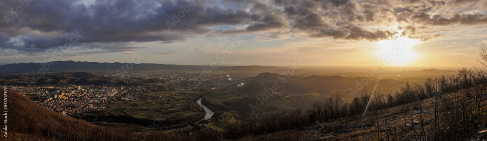 Fototapeta premium ampia composizione panoramica con vista dalla cima di un alto monte, sul vasto territorio tra pianura e collina della regione Friuli Venezia Giulia, nel nord est Italia, al tramonto