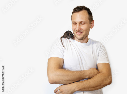 Isolated young Caucasian man with black rat on white background, adorable home pet.