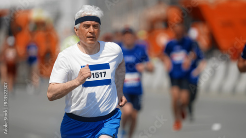 Male old runner jog sport marathon. Senior man athlete run. Elder jogger work out urban park. 60s sportsman train body. Health city life. Fast race slow motion. Active fit track. Motivation concept. photo