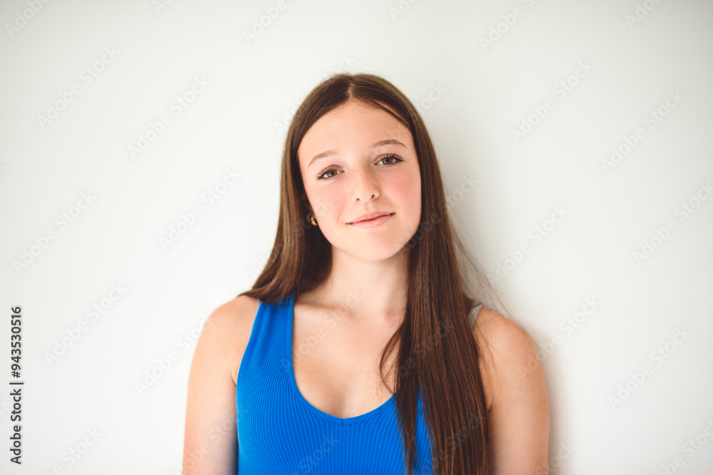 portrait of a 14 years old teen girl close to a white wall with colored shirt