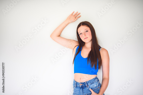 portrait of a 14 years old teen girl close to a white wall with colored shirt photo