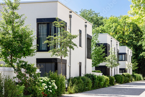 Modern Apartment Building in Green City. Low-rise Residential Buildings with Modern Exterior Design White Facade, Flat roof and Landscaping. Contemporary Facade Building in Germany.