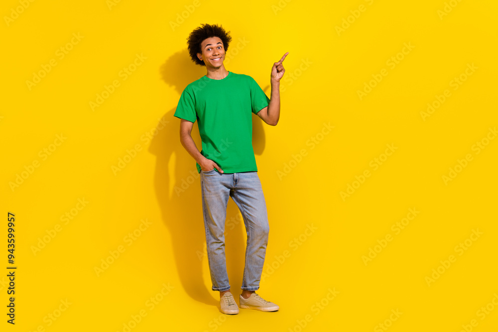 Full length photo of handsome good mood guy wear green t-shirt showing emtpy space isolated yellow color background Full length photo of handsome good mood guy wear green t-shirt showing emtpy space isolated yellow color background
