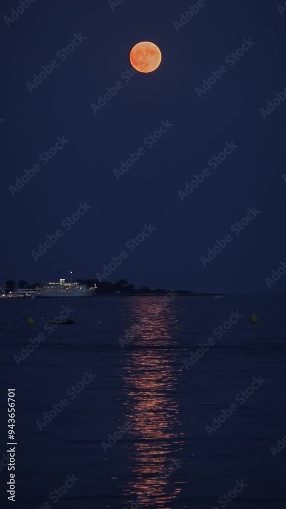 Boats on the sea in the evening with the moon up in the sky. Vertical Boats on the sea in the evening with the moon up in the sky. Vertical