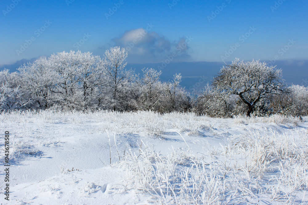 A sunny winter day in the mountains. The trees are covered with frost and there is a lot of snow on the ground. A sunny winter day in the mountains. The trees are covered with frost and there is a lot of snow on the ground.