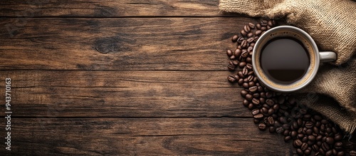 a warm cup of coffee with a sack beside coffee beans on a wooden background. with copy space image. Place for adding text or design