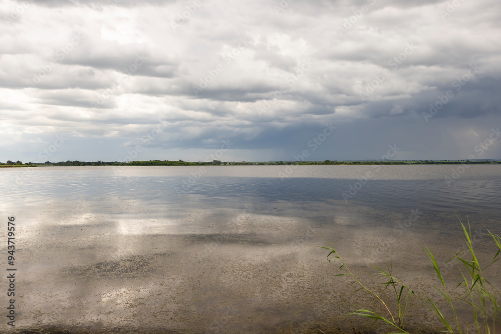 Fototapeta premium lake and trees on the shore before a storm