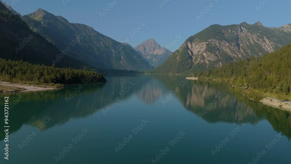 Breathtaking view of Lake Plansee in Tyrol, Austria, showcasing serene water reflections and majestic mountains. Breathtaking view of Lake Plansee in Tyrol, Austria, showcasing serene water reflections and majestic mountains.