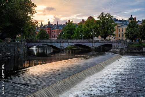 Sunset view of Orebro charming town cityscape with stone bridge over Svartan river and historic buildings on background . Nordic destinations and historic architecture concept. Sweden