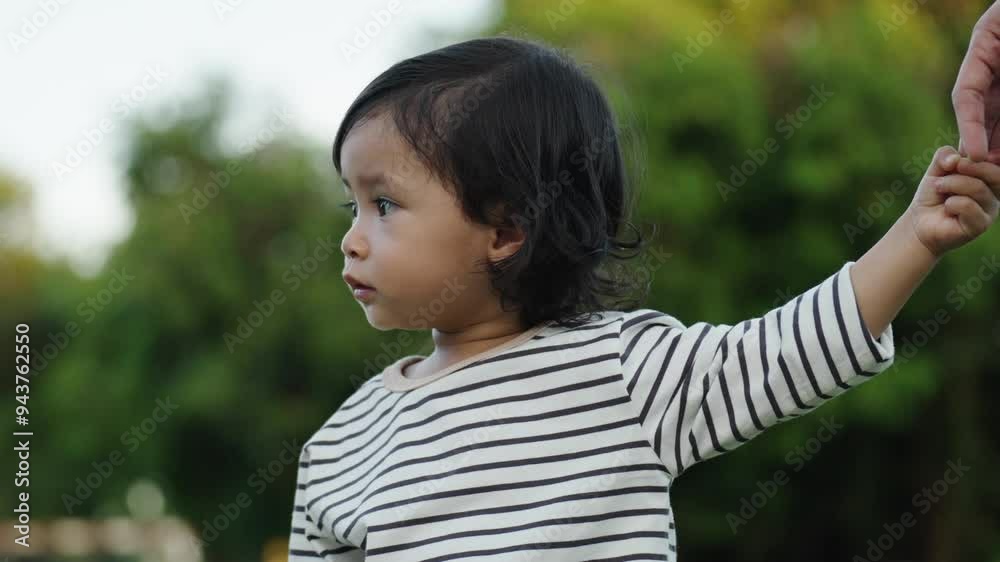 little toddler girl holding her mother's hand in a grass field little toddler girl holding her mother's hand in a grass field