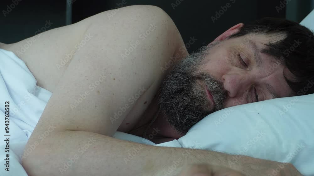A bearded man is sleeping in bed. The concept sleep. A bearded man is sleeping in bed. The concept sleep.