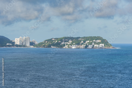 A beautiful view of some hills surrounded by the sea of the coast of Guaruja city, SP, Brazil.