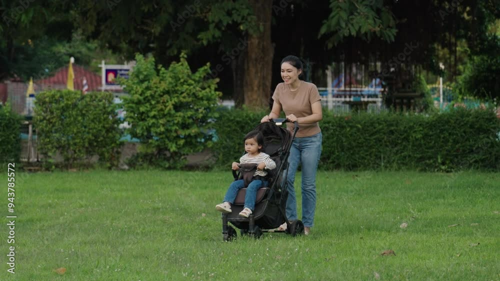 mother pushing toddler baby stroller and walking in the park mother pushing toddler baby stroller and walking in the park