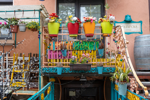 A colorful balcony with potted plants and a sign that says 