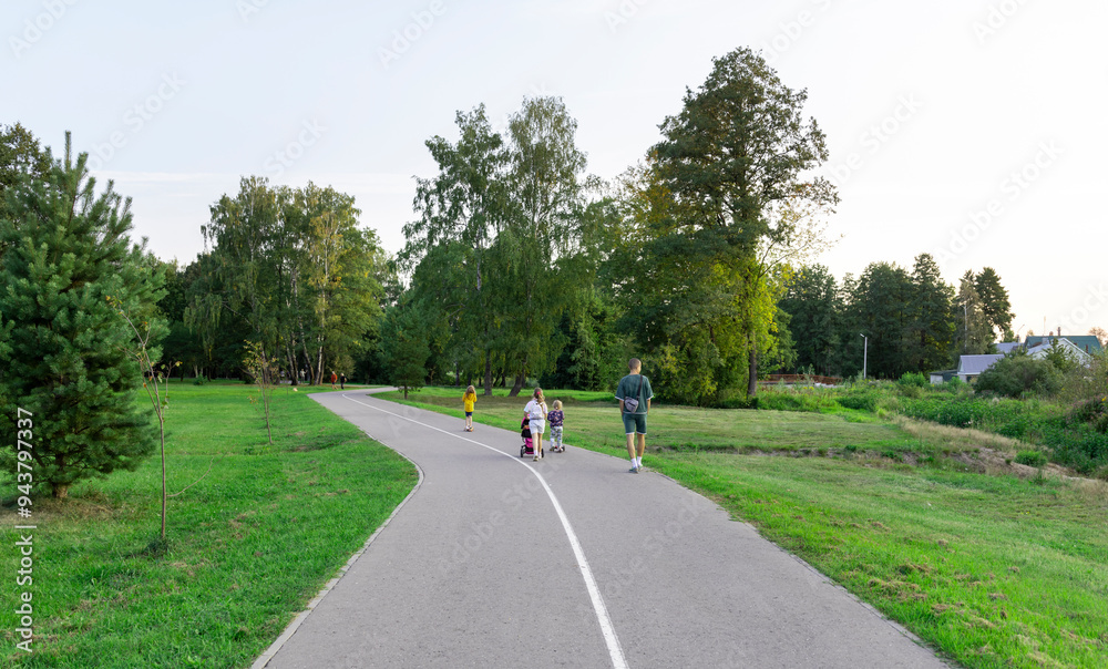 A group of people are walking down a path in a park A group of people are walking down a path in a park