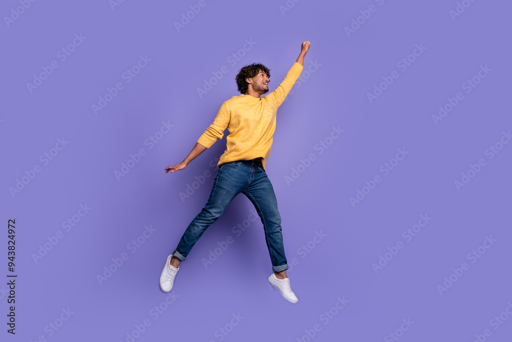 Photo of cheerful glad funny man wear trendy yellow clothes flight empty space isolated on purple color background