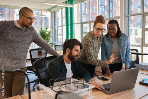 Focused group of diverse businesspeople working together on a laptop