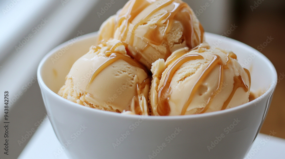 Gourmet caramel ice cream scoops drizzled with sweet sauce in a white bowl. Gourmet caramel ice cream scoops drizzled with sweet sauce in a white bowl.