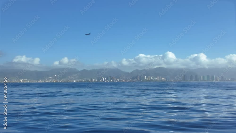 Aerial of blue water of north pacific ocean, Waikiki skyline and diamond head mountain in the background in waikiki, honolulu, Oahu Hawaii seen from catamaran boat. Aerial of blue water of north pacific ocean, Waikiki skyline and diamond head mountain in the background in waikiki, honolulu, Oahu Hawaii seen from catamaran boat.