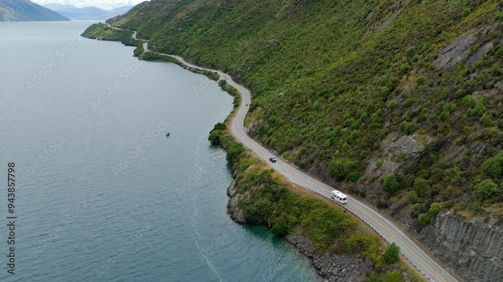 Drone birds eye view, vehicles on Devil's Staircase Lookout Point Road beside lush green mountains and Lake Wakatipu near Queenstown, New Zealand. Drone birds eye view, vehicles on Devil's Staircase Lookout Point Road beside lush green mountains and Lake Wakatipu near Queenstown, New Zealand.