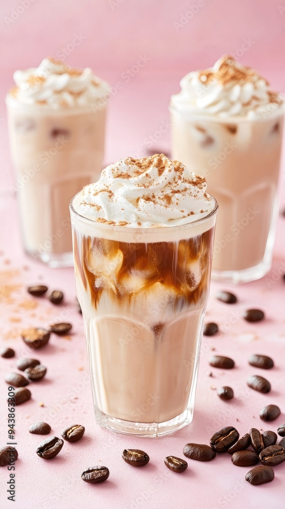 Ice coffee in a tall glass with cream poured over and coffee beans. Set with different types of coffee drinks on a pink table. Ice coffee in a tall glass with cream poured over and coffee beans. Set with different types of coffee drinks on a pink table.
