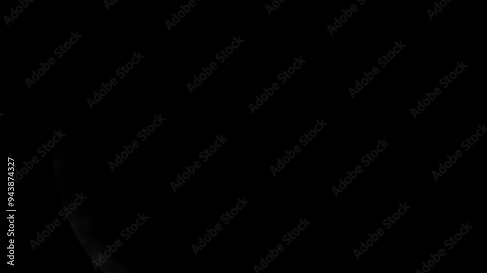 Partial view of a full moon close up obscured by moving clouds in a dark night sky Partial view of a full moon close up obscured by moving clouds in a dark night sky