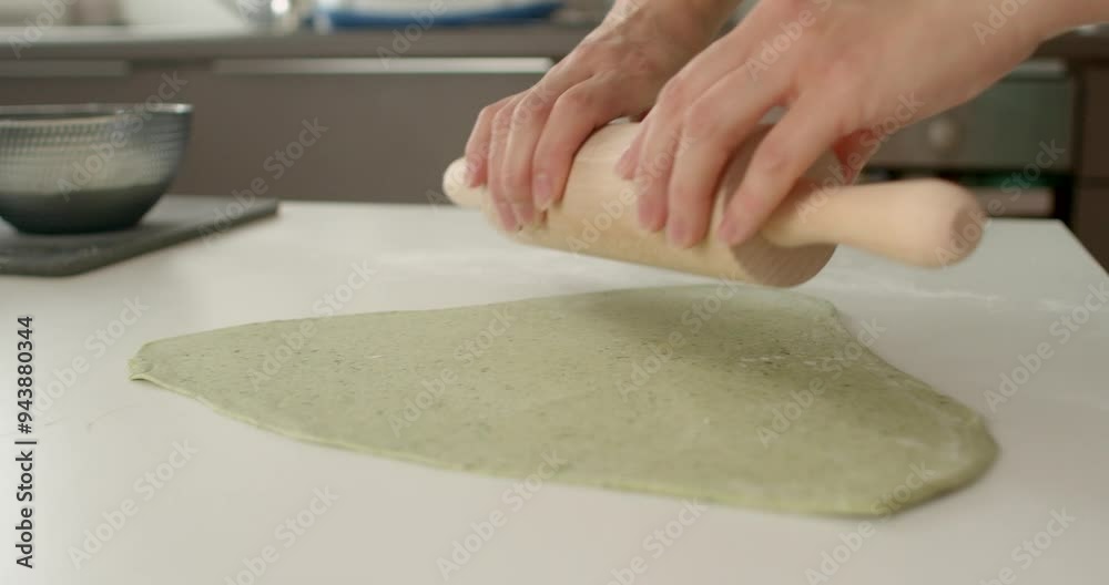 showcasing culinary artistry Roll out the dough with your hands using a wooden roller skilled chef expertly rolls out vibrant green dough on pristine countertop showcasing culinary artistry Roll out the dough with your hands using a wooden roller skilled chef expertly rolls out vibrant green dough on pristine countertop