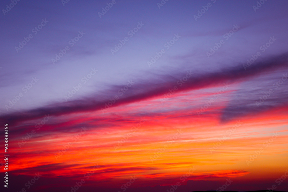 Obraz premium The dance of the clouds at sunset. Purple and orange sky