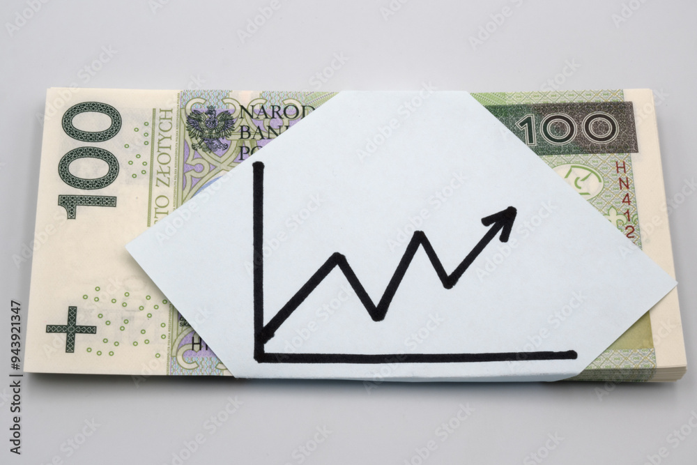 Polskie banknoty stu złotowe i wykres wzrostu.