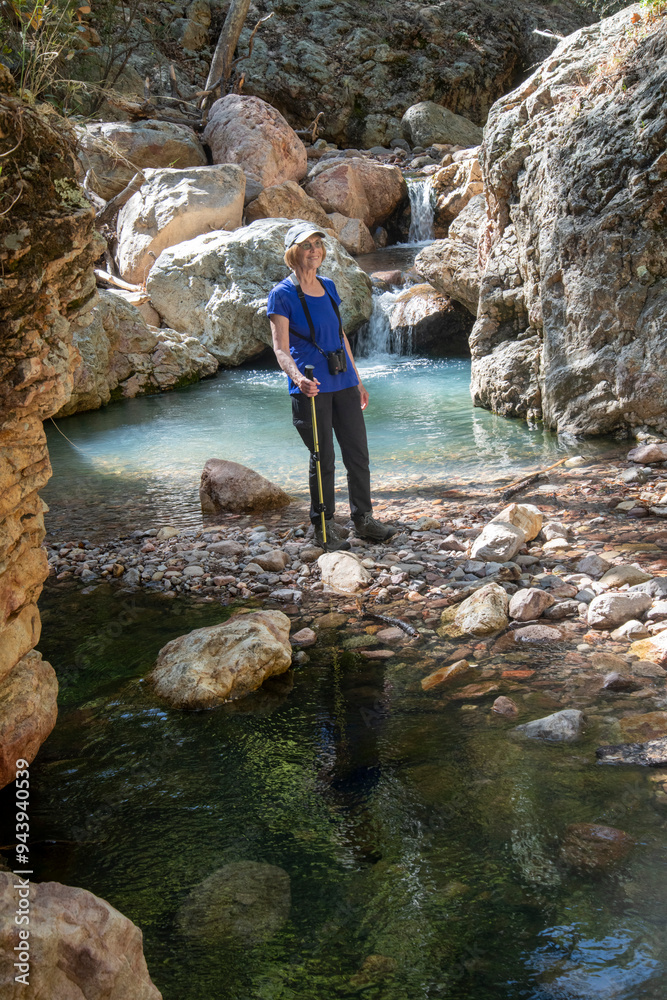 Portrait of a female hiker smiling while standing by a pool in the South Fork of Cave Creek in the Chiricahua Mountains of Southeast Arizona; Arizona, United States of America Portrait of a female hiker smiling while standing by a pool in the South Fork of Cave Creek in the Chiricahua Mountains of Southeast Arizona; Arizona, United States of America