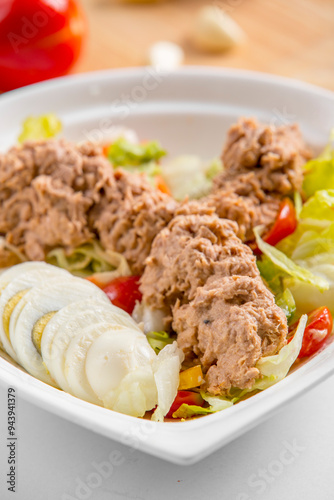 tuna salad with boiled eggs and vegetables on a plate restaurant menu