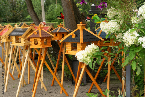Wooden decorative bird feeders on legs at the market.