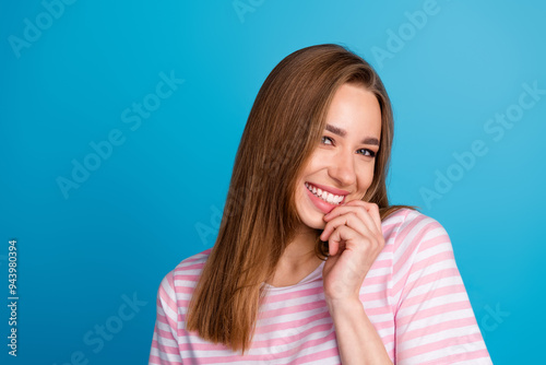 Photo portrait of lovely young lady charming sweet shy smile dressed stylish striped pink garment isolated on blue color background