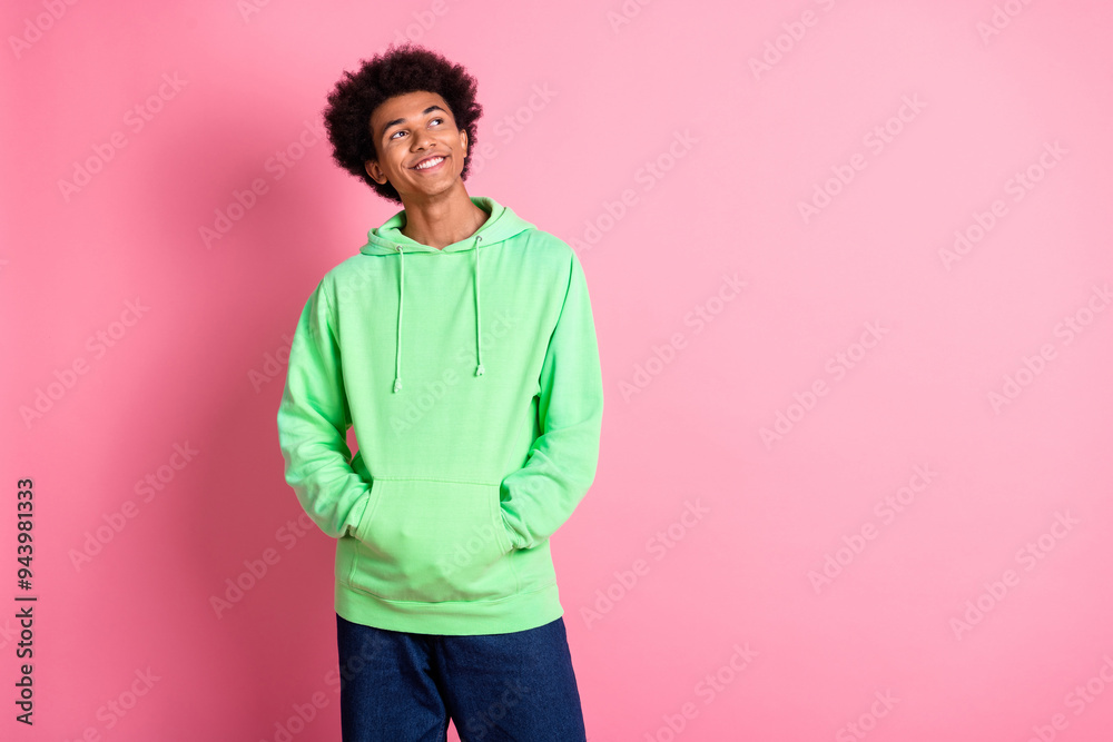Portrait of cool young man look empty space wear green hoodie isolated on pink color background Portrait of cool young man look empty space wear green hoodie isolated on pink color background